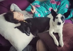 Lori lying down with two dogs