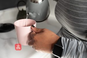 woman making tea with a smart watch on