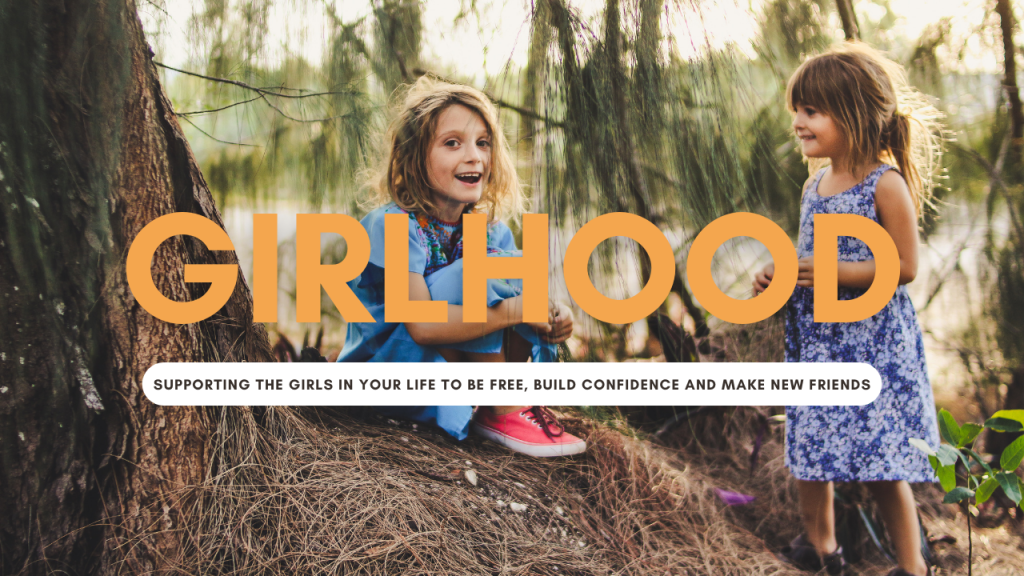 Two girls running free in the woods celebrating girlhood. The writing states 'Girlhood, supporting the girls in your life to be free, build confidence and make new friends'